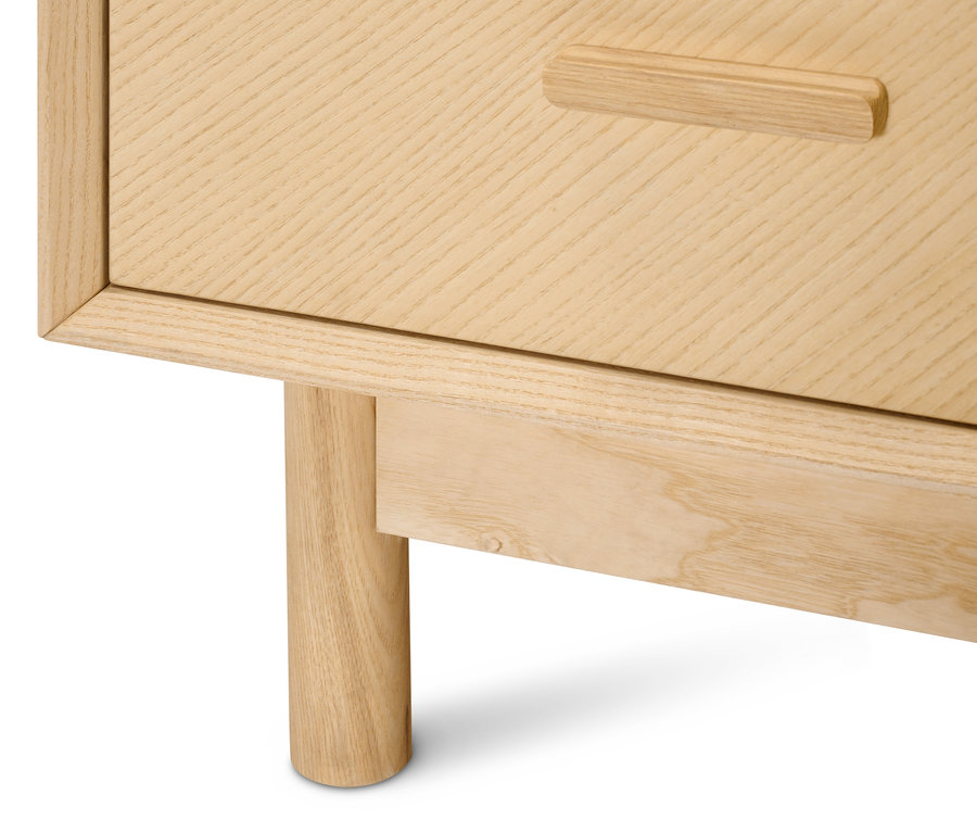 Detail einer Schubladenkommode aus Eschenholz mit dekorativen Fronten.