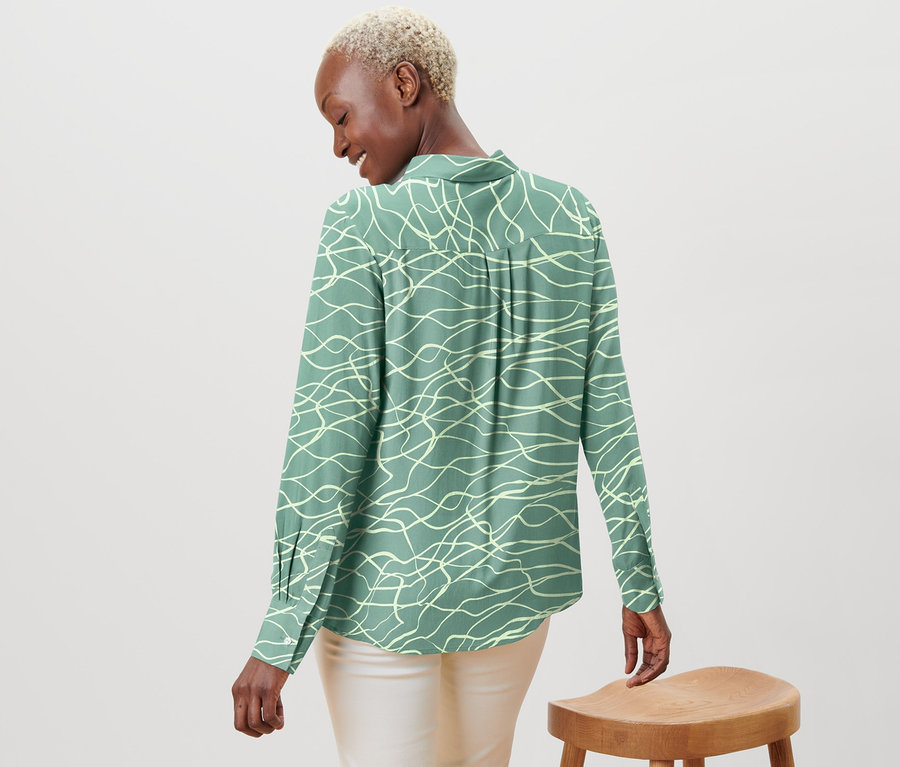 Frau von hinten gesehn mit bedruckter Bluse.