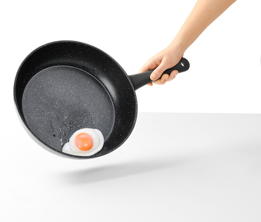 Hand hält eine 28 cm Profi-Pfanne in Steinoptik mit Spiegelei.