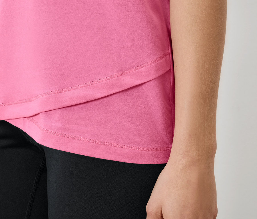 Detailaufnahme eines pinkfarbenen Damen-T-Shirts und schwarzen Leggings.