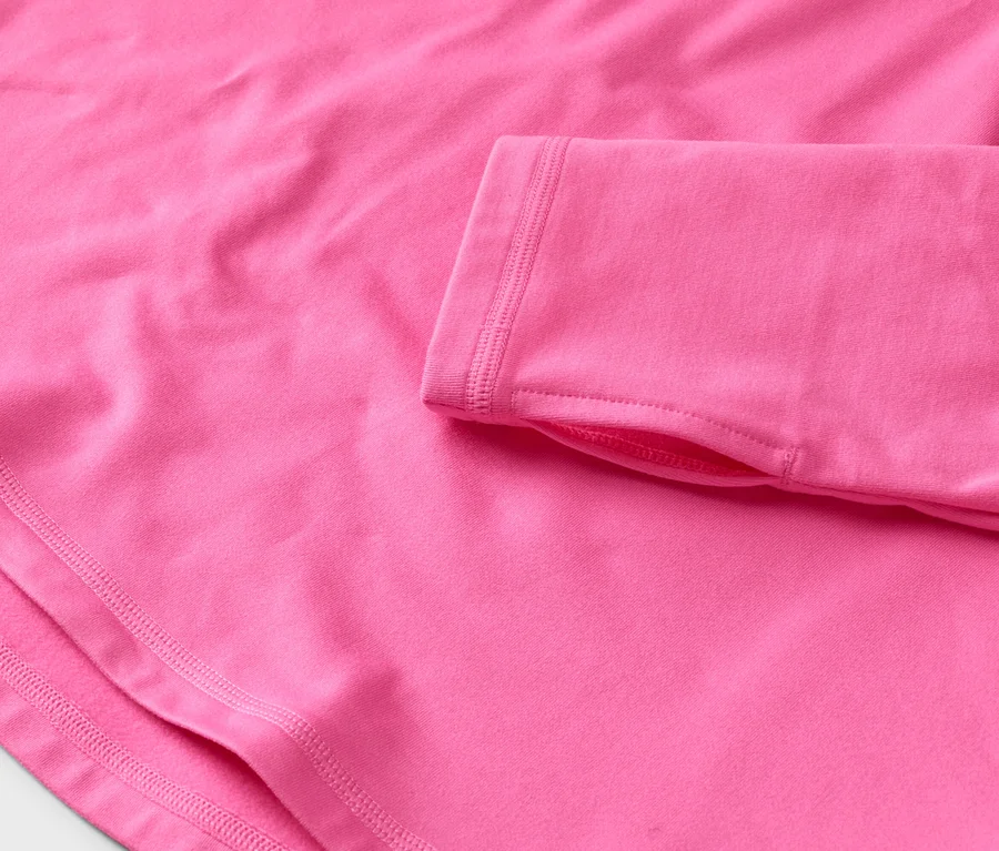 Nahaufnahme eines pinkfarbenen, langärmeligen Oberteils mit Daumenlöchern.