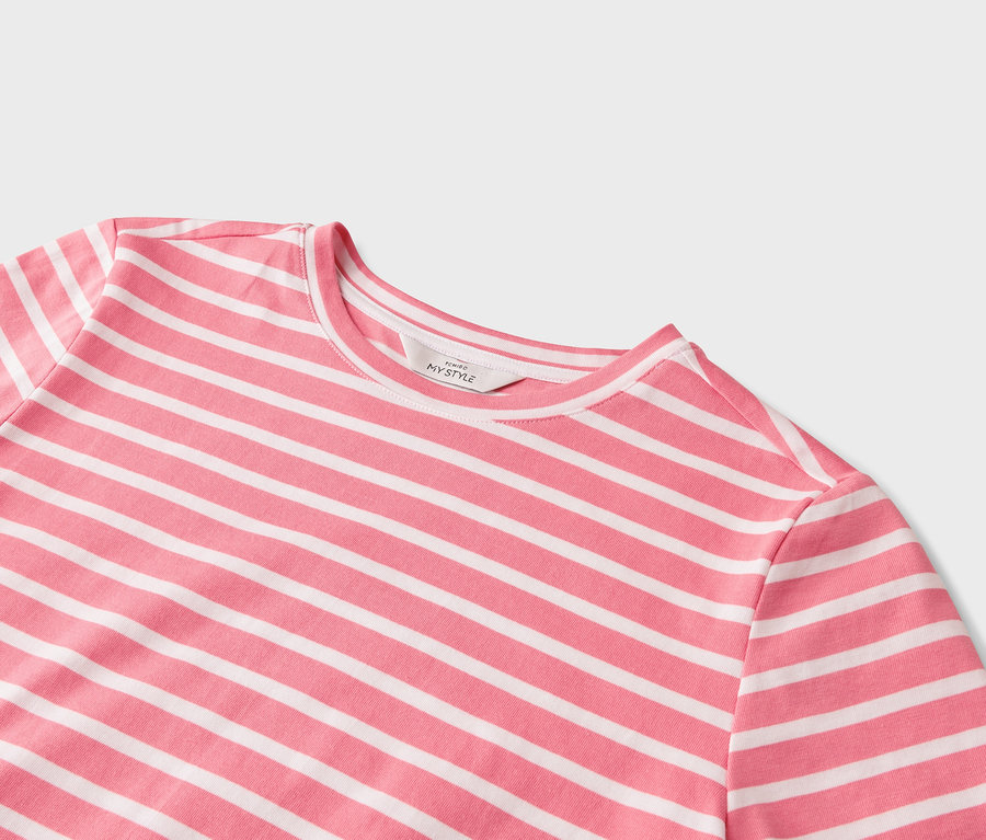 Nahaufnahme eines T-Shirts mit rosa-weissen horizontalen Streifen.