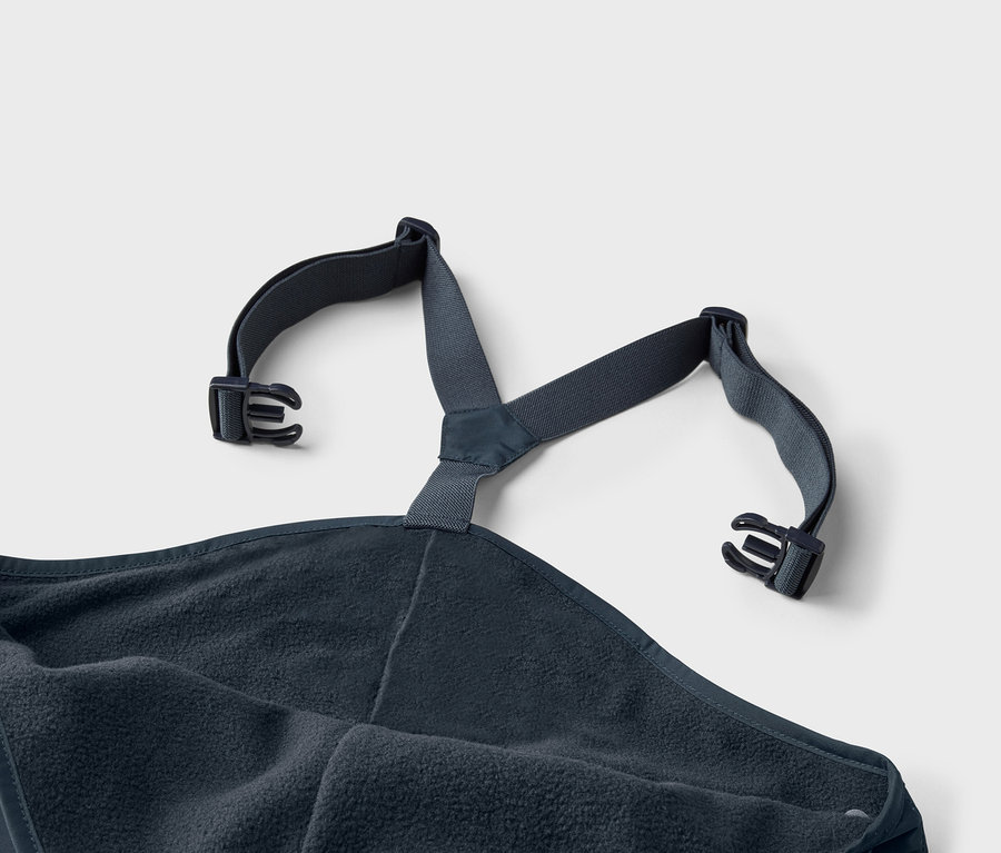 Nahaufnahme eines marineblauen Badeponchos mit Fleece-Innenseite und verstellbaren Trägern mit Schnallen.