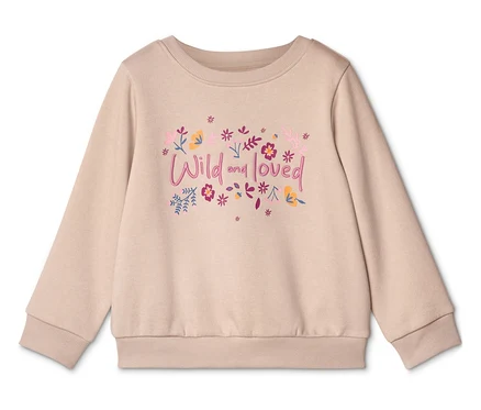 Ein beiger Pullover mit der Aufschrift "Wild and loved" und Blumenmotiven ist auf einem weißen Hintergrund zu sehen.