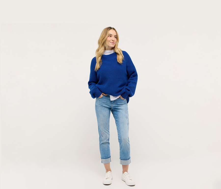 Frau trägt blaue Strickjacke und Angels Denim »Cira Boho« Jeans.