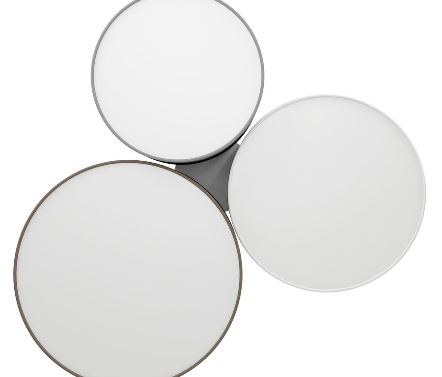 Deckenleuchte mit drei runden Lichtelementen, die jeweils einen weißen Diffusor und einen unterschiedlich farbigen Metallrand (dunkelgrau, hellgrau und weiß) haben. Sie sind in einer Dreiecksform angeordnet und durch eine graue Basis verbunden.