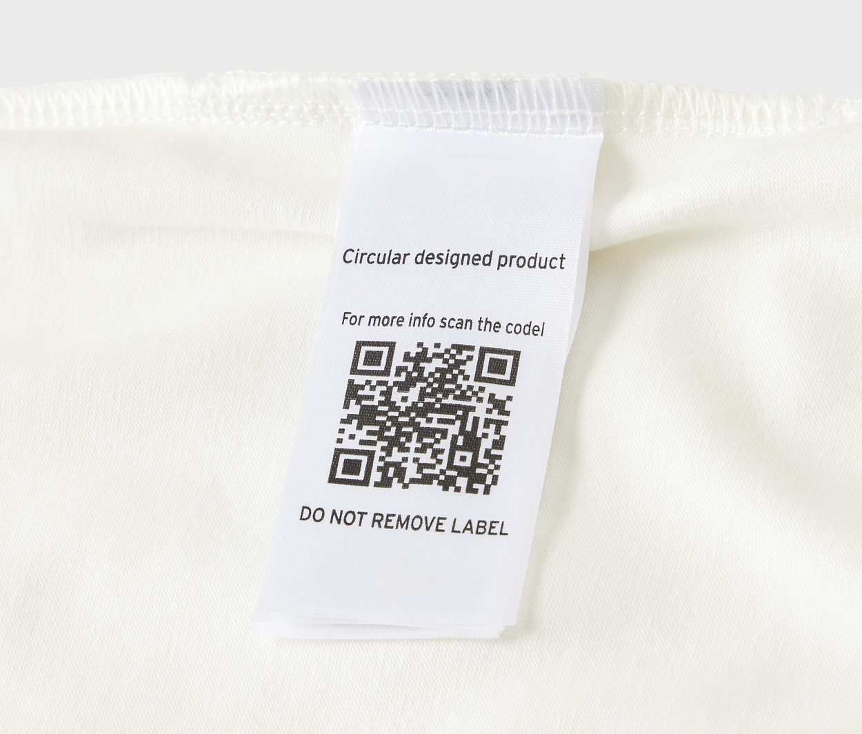 Detailansicht eines 5er-Packs Baby-Bodys mit Mitwachsfunktion, Etikett mit QR-Code.