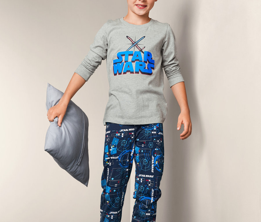 Junge mit Kissen trägt einen »Star Wars« Pyjama.