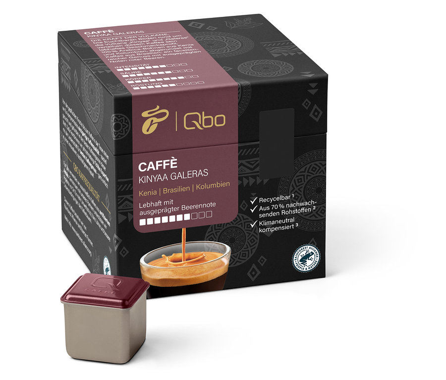 Eine Packung Qbo Caffè KINYAA GALERAS und eine Kaffeekapsel. Kaffee fließt aus der Packung in eine Tasse.