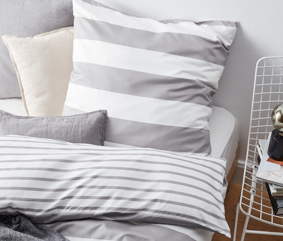 Gestreifte, graue Microfaser-Bettwäsche. Das Set beinhaltet ein Bettlaken, ein Kissen und eine Decke.