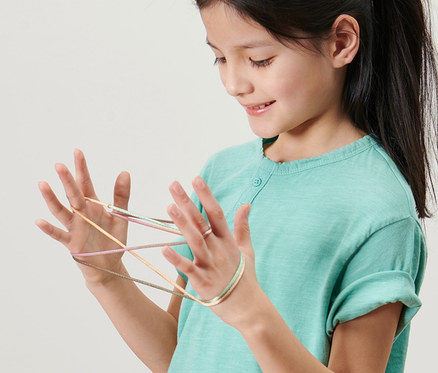 Mädchen spielt Fingertwist, 2er-Set, mit der Schnur an ihren Händen.