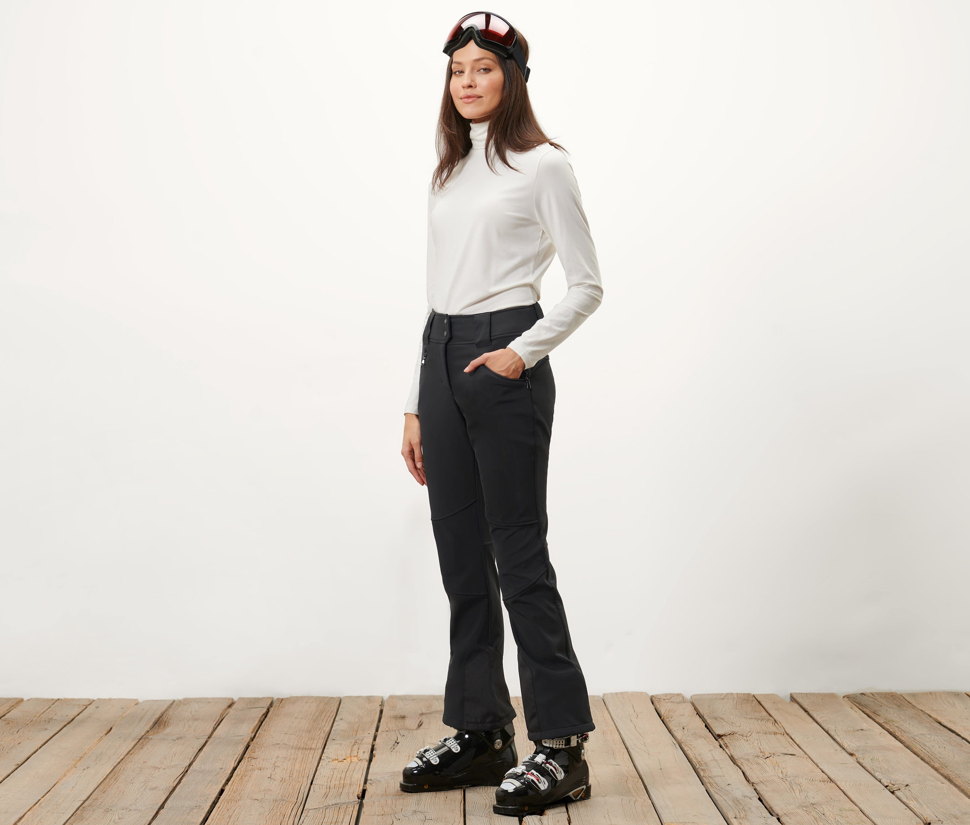 Frau posiert in Jet-Skihose und Skischuhen.