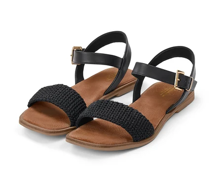 Zwei Ledersandalen mit Häkelriemen liegen nebeneinander.