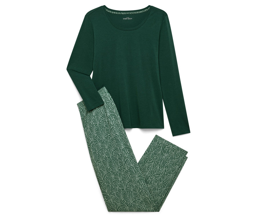 Ein grüner Schlafanzug mit langen Ärmeln und einer Hose mit grünem Blättermuster liegt auf einem weißen Hintergrund.