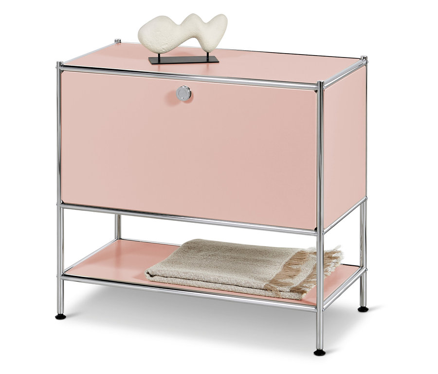 Rosa Schrank mit Chromrahmen und beige Decke auf dem unteren Regal.