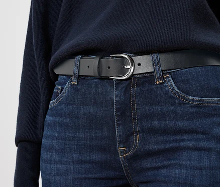 Schwarzer Ledergürtel auf blauen Jeans.