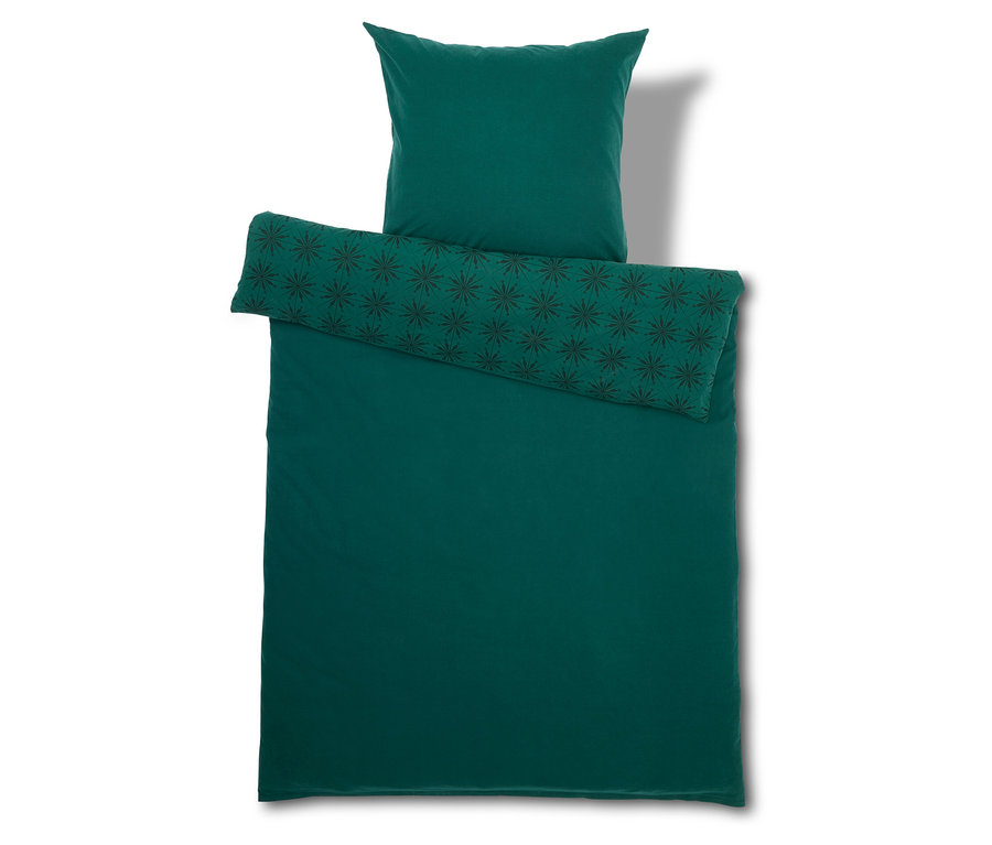 Grüne Bettwäsche mit Kissen und Bettdecke.