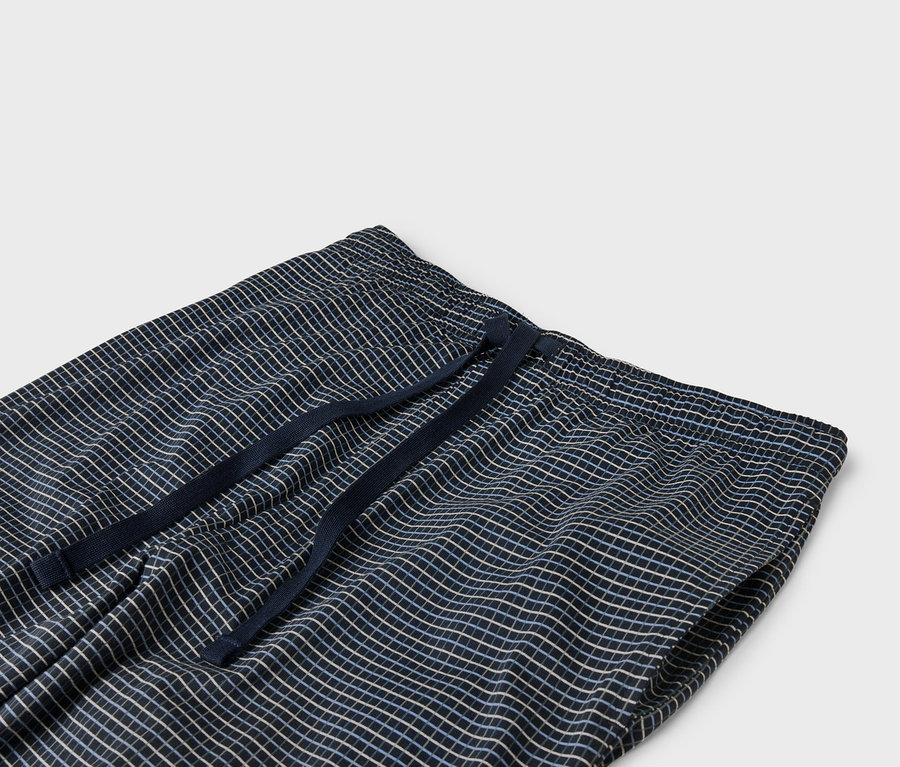 Detailaufnahme einer marineblauen, karierten Hose mit elastischem Bund und Kordelzug.