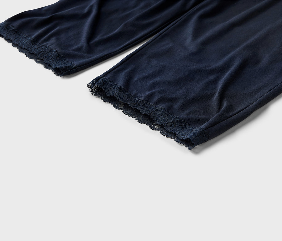Nahaufnahme von marineblauen Pyjamahosen mit Spitzensaum