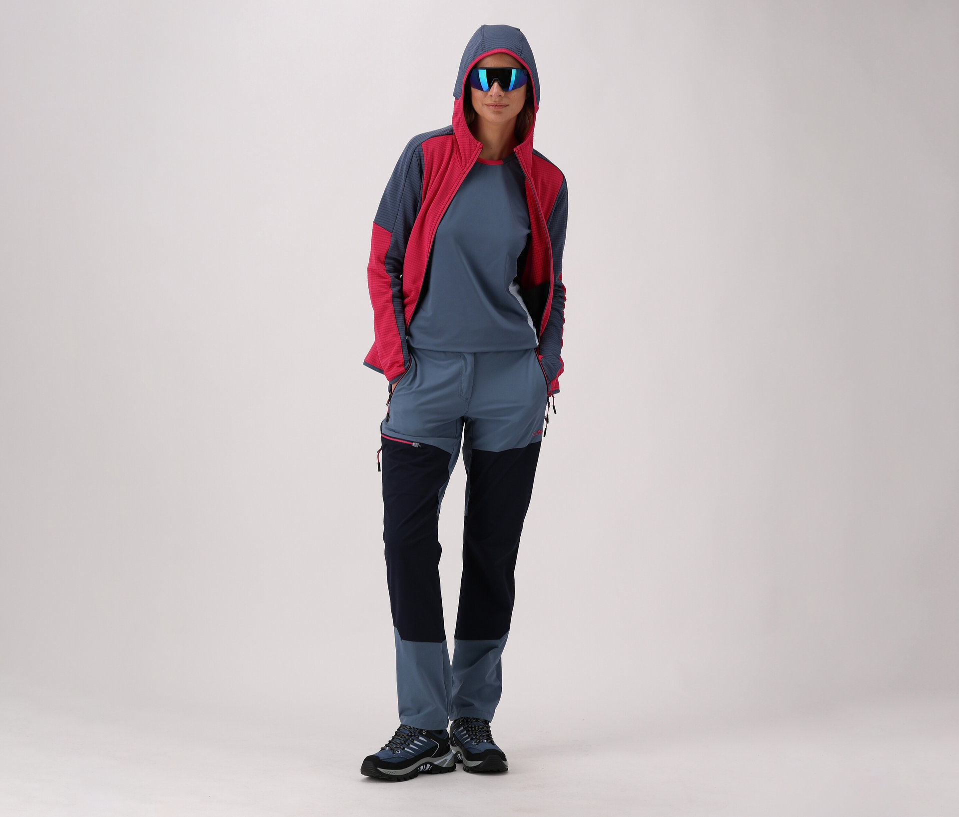 Frau mit Sonnenbrille, CMP Damen-Jacke mit Kapuze und CMP Damen-Trekkingschuh Rigel Low 2.0 WP, blau.