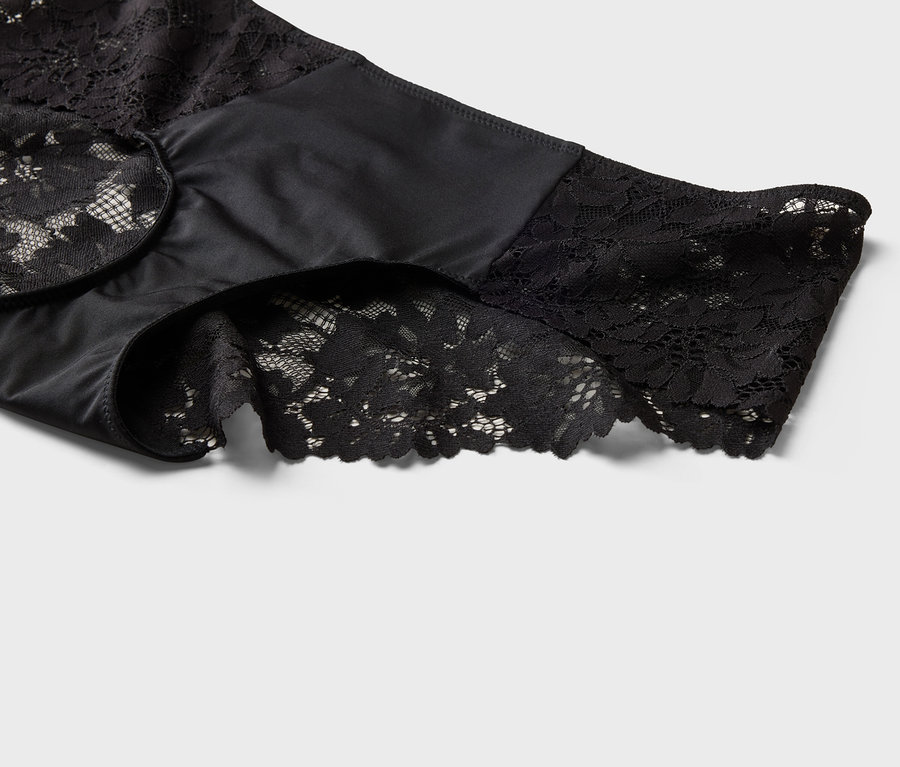 Nahaufnahme einer schwarzen, hochtaillierten Unterhose mit Spitzendetails an Beinabschlüssen und Bund.