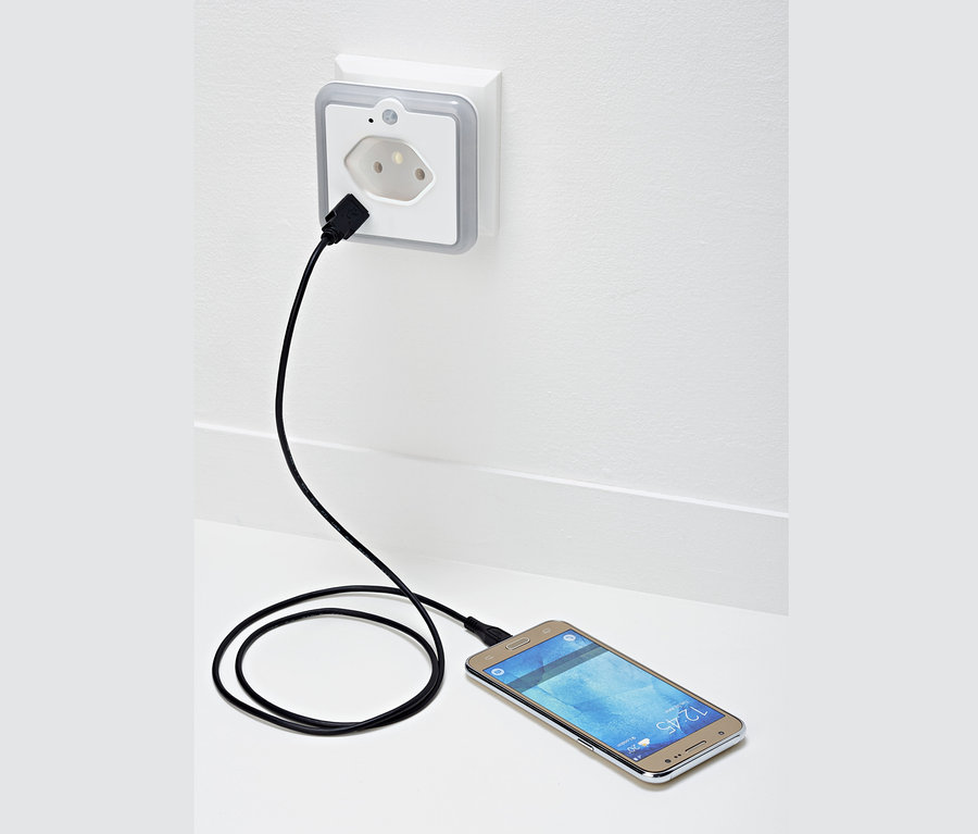 Handy wird über LED-Nachtlicht aufgeladen.