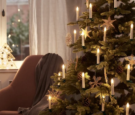 Ein Weihnachtsbaum ist mit 30 LED-Weihnachtsbaumkerzen und Schmuck geschmückt.