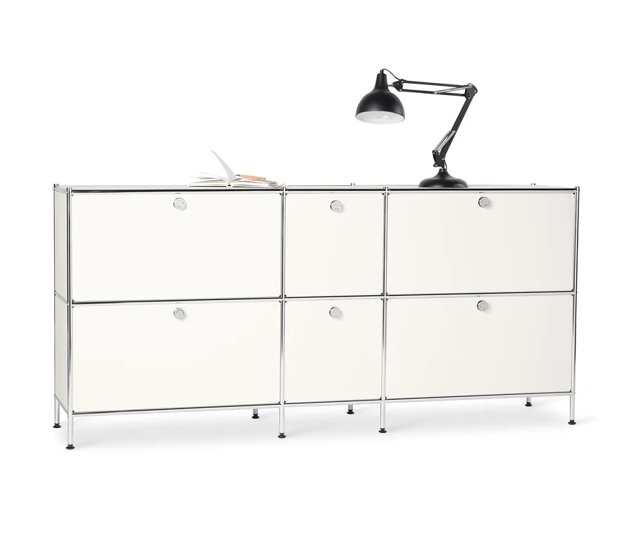 Weißes Sideboard Metall »CN3« groß mit 6 Klappenfächern. Auf der Oberseite liegen ein offenes Notizbuch und eine schwarze Lampe.