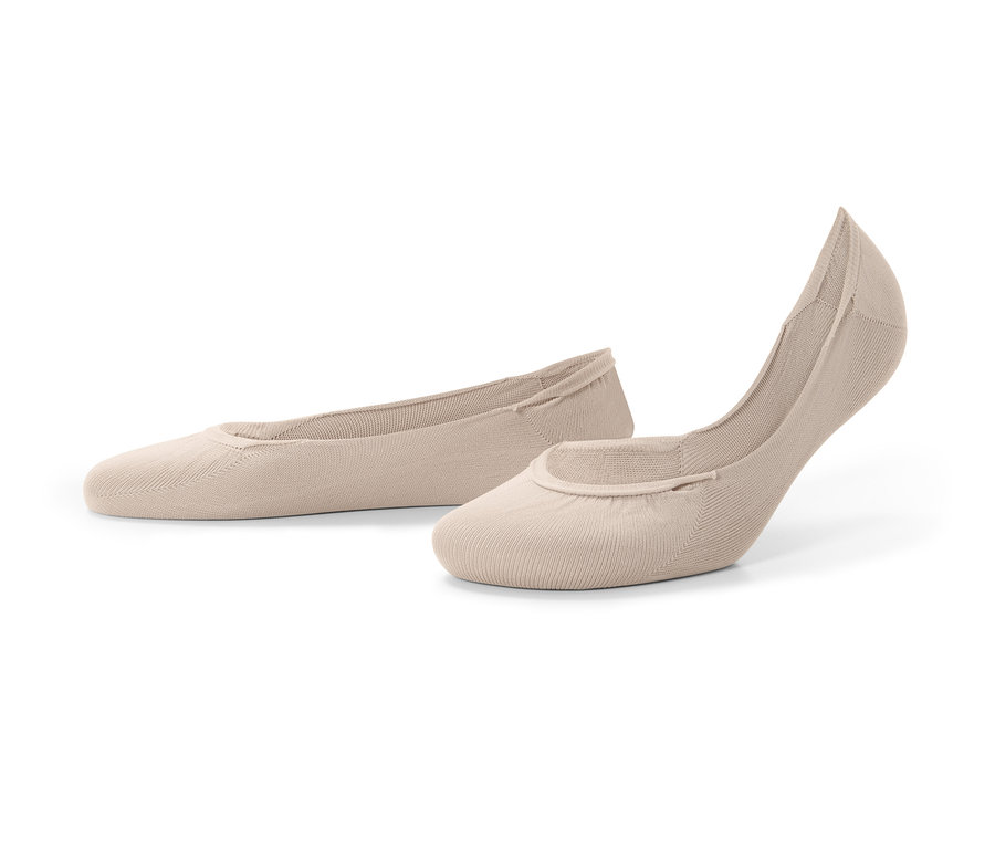 Zwei Paar hautfarbene Füßlinge liegen auf dem Untergrund.