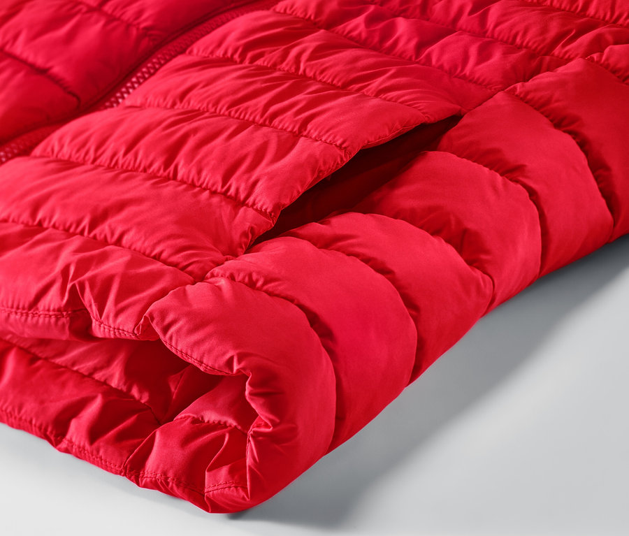 Detailansicht einer roten Steppweste mit Kapuze und Tasche.