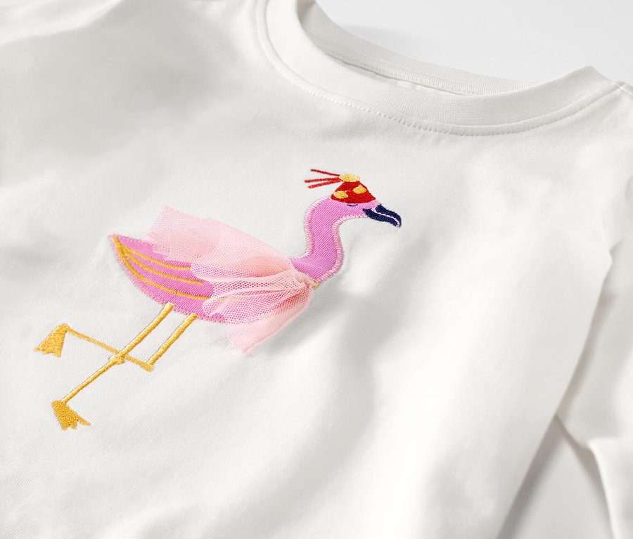 Detailansicht eines Kinder-Langarmshirts mit aufgesticktem Flamingo mit Tutu und Geburtstagshut.
