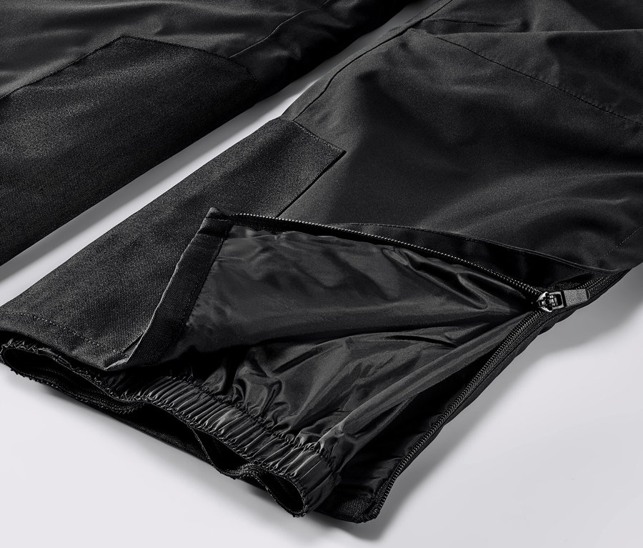 Detailaufnahme einer schwarzen High-Tech-Skihose mit Reißverschluss am Bein.