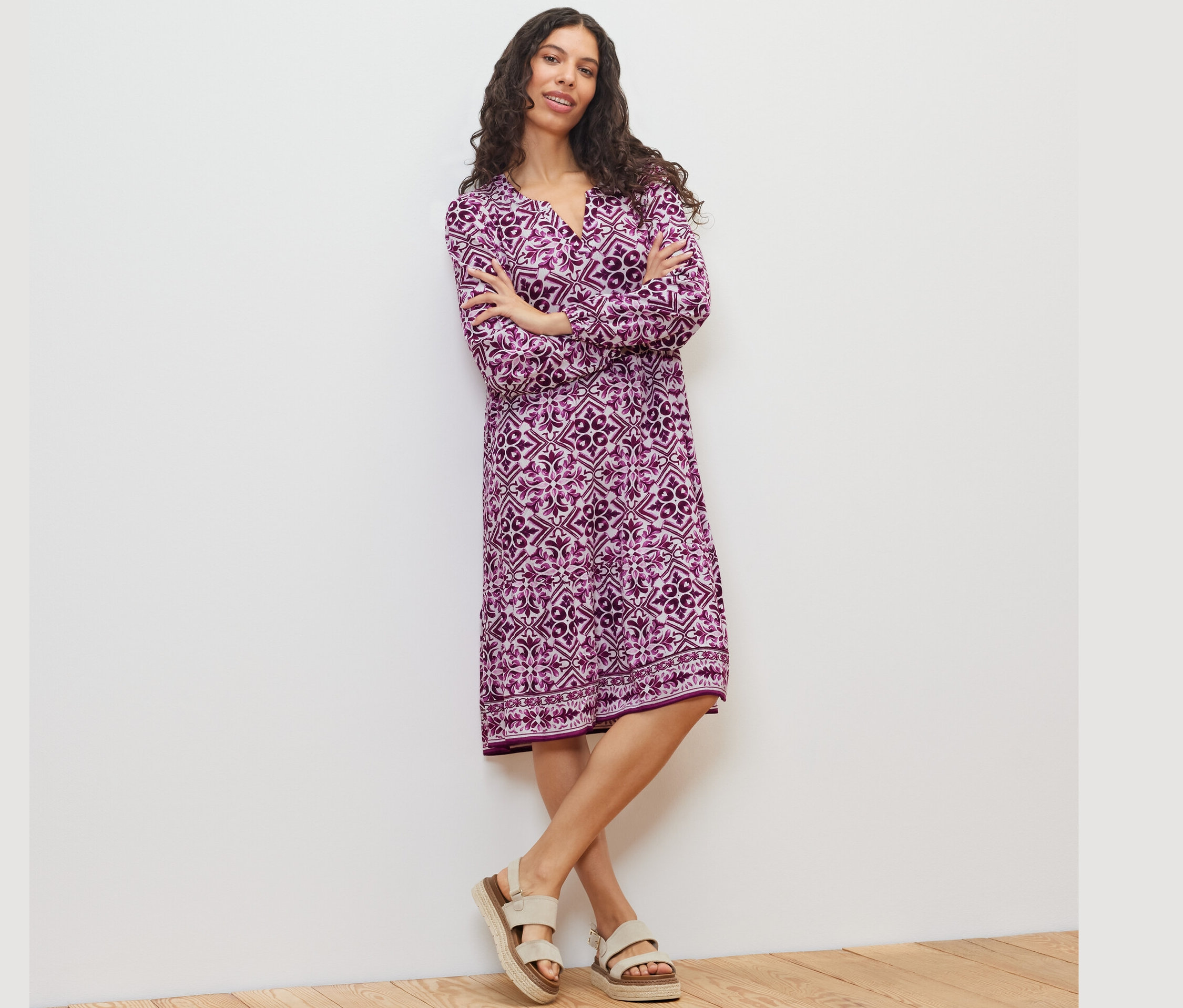 Frau posiert in einem bedruckten Webkleid.