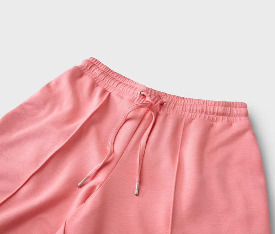Nahaufnahme von korallfarbenen Hosen mit Kordelzug.