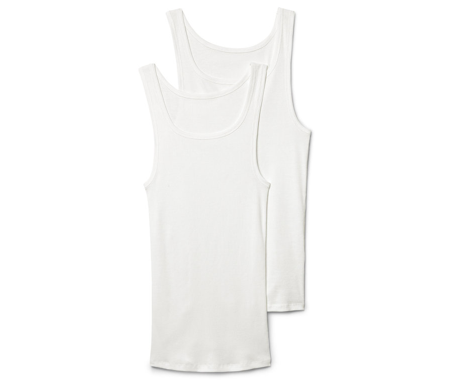 Zwei weiße Tanktops liegen übereinander, wobei das obere Tanktop teilweise verdeckt ist.