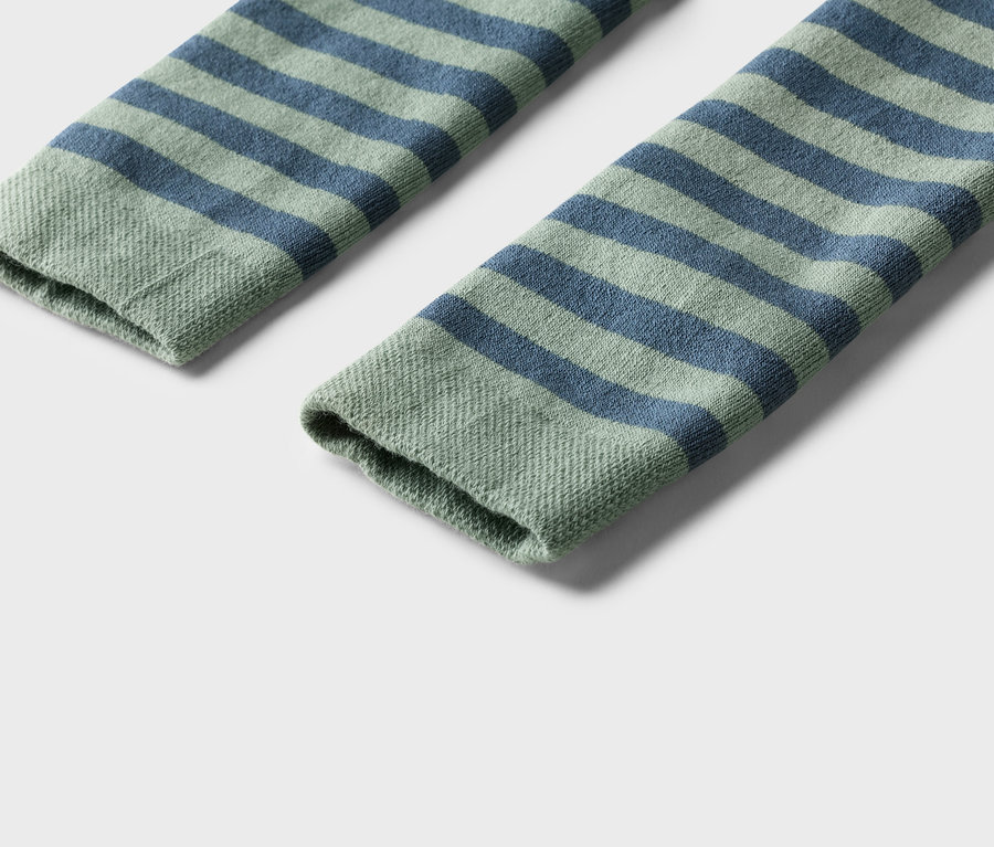 Nahaufnahme von zwei geringelten Socken in Grün und Blau auf einem weißen Hintergrund.