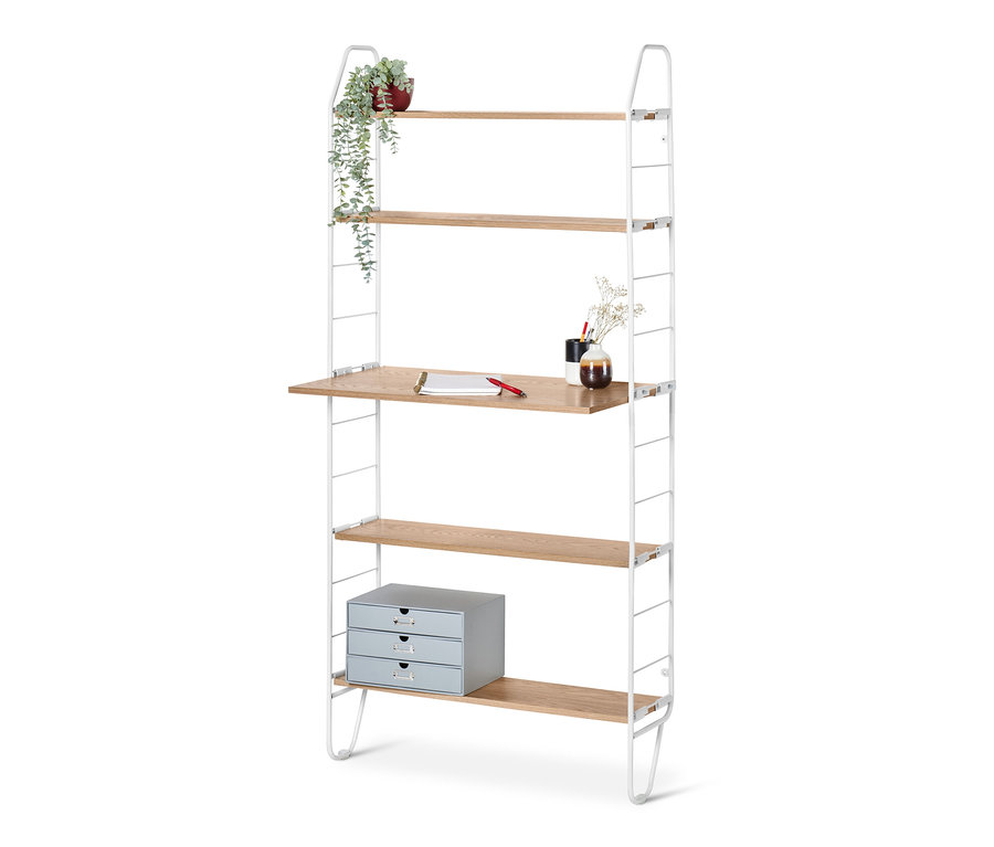 Ein Wandregal mit Arbeitsfläche, auf der ein Notizbuch und ein Stift liegen. Auf den oberen Regalen befinden sich eine Blume und eine Vase.