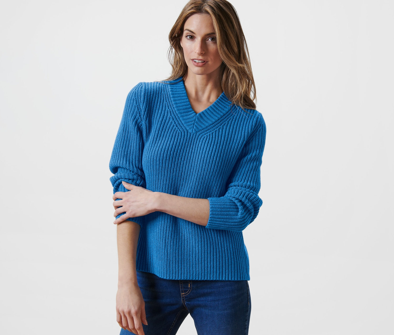 Frau posiert in blauem Strickpullover.