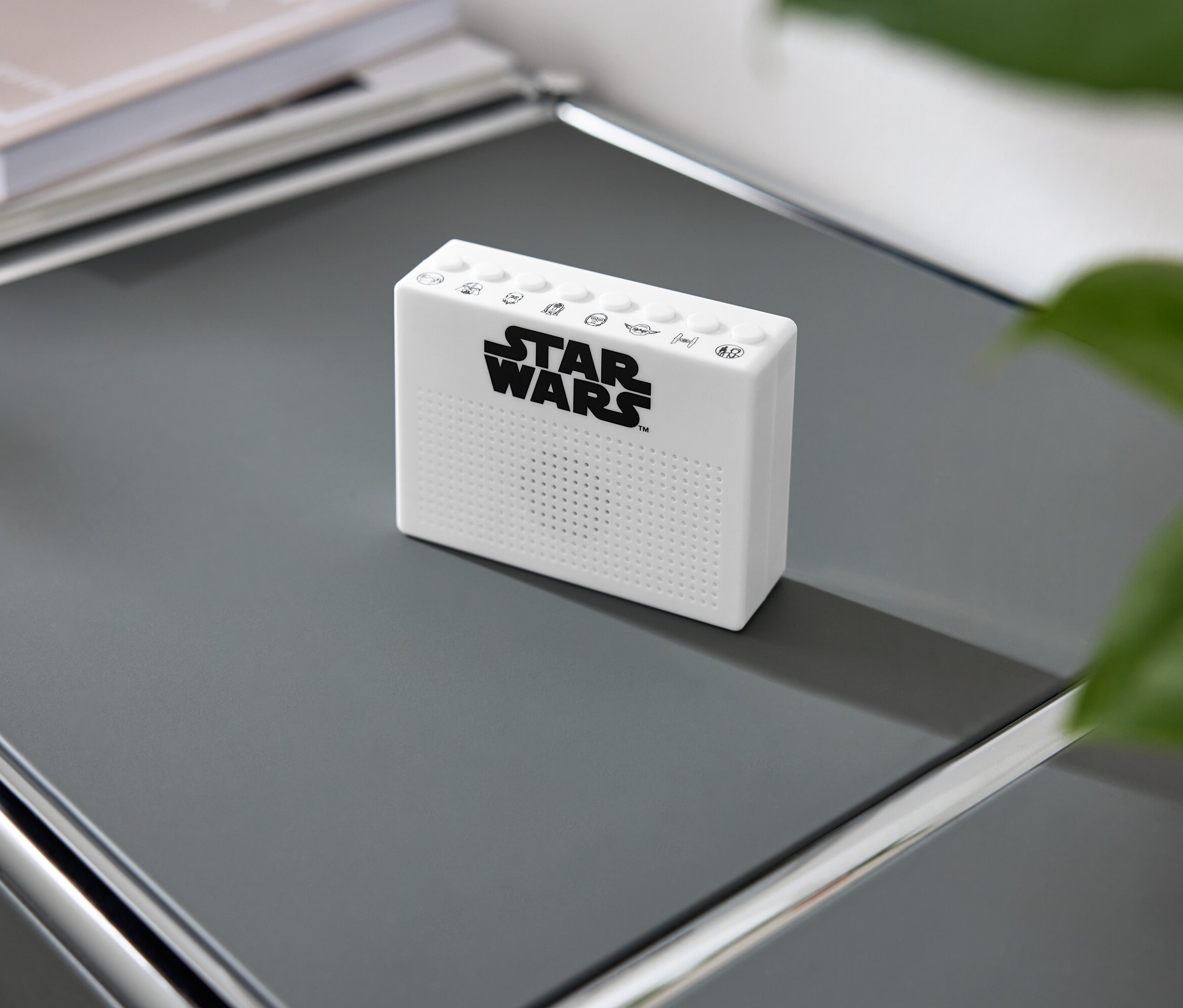 Eine weiße Star Wars Soundbox auf einem grauen Regal.