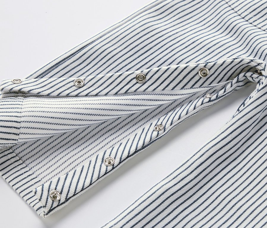 Detailaufnahme einer Kinder-Web-Latzhose mit blauen Streifen und Druckknöpfen.