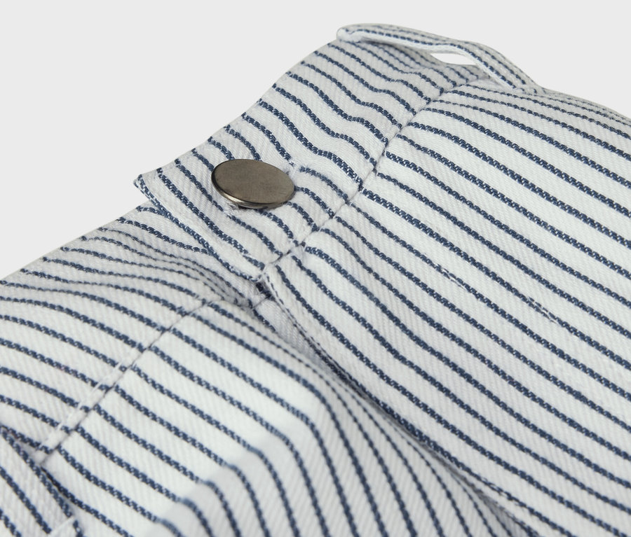 Detailaufnahme einer Kinder-Webhose mit blauen Streifen und Knopf.