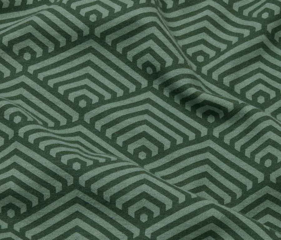 Nahaufnahme von zwei grünen Biber-Kopfkissenbezügen mit geometrischem Muster.