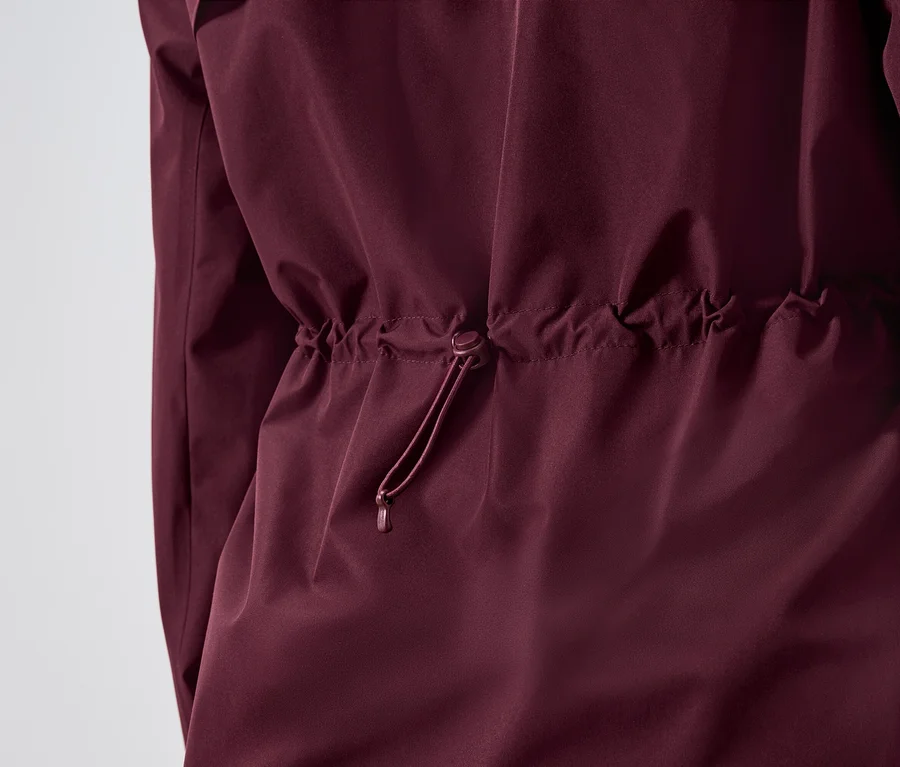 Nahaufnahme einer weinroten Jacke mit Tunnelzug in der Taille.