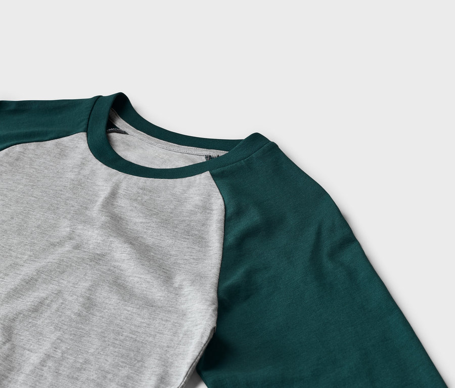 Nahaufnahme eines Langarmshirts mit grauem Rumpf und dunkelgrünen Raglanärmeln sowie einem dunkelgrünen Rundhalsausschnitt.