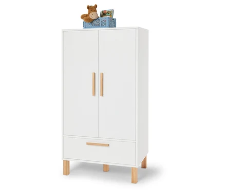 Weißer Kleiderschrank mit Holzakzenten, darauf eine blaue Kiste mit einem Stofftier und Büchern.