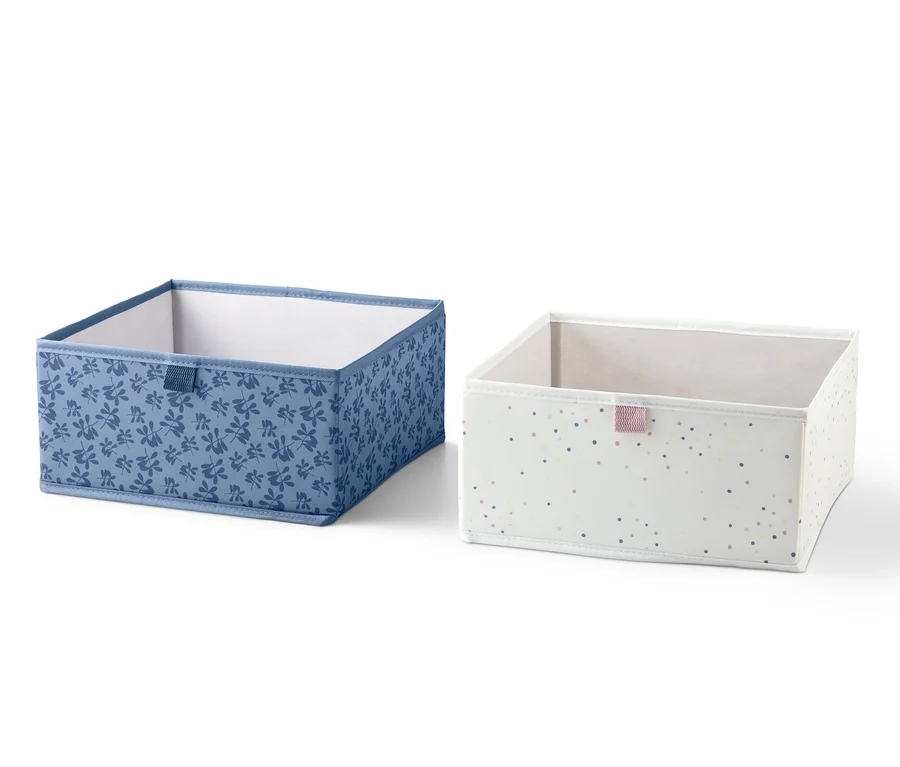 Zwei quadratische Schubladen-Ordnungsboxen. Eine blau mit Blumenmuster, die andere weiß mit Punkten.