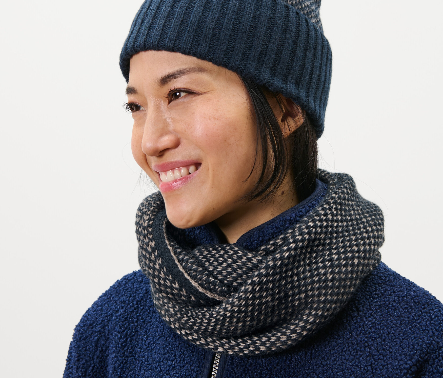 Frau trägt einen Strick-Loopschal und eine Mütze.