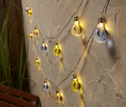 LED-Lichterkette mit blau und gelb gefärbten Glühbirnen an einer Wand.