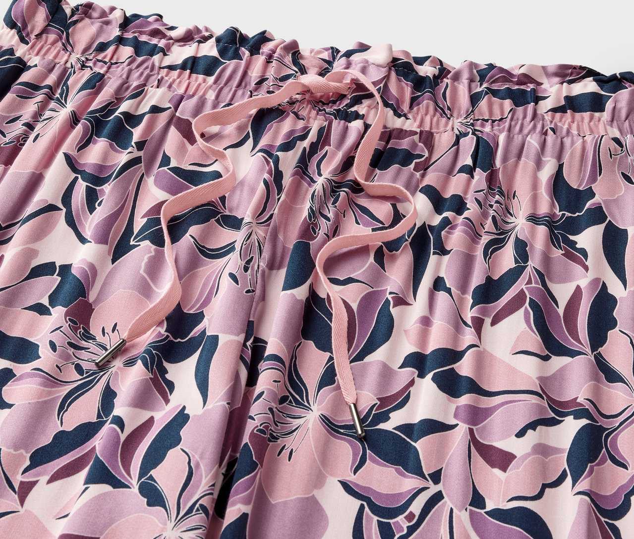 Nahaufnahme einer Relaxhose mit Blumenmuster und Kordelzug.