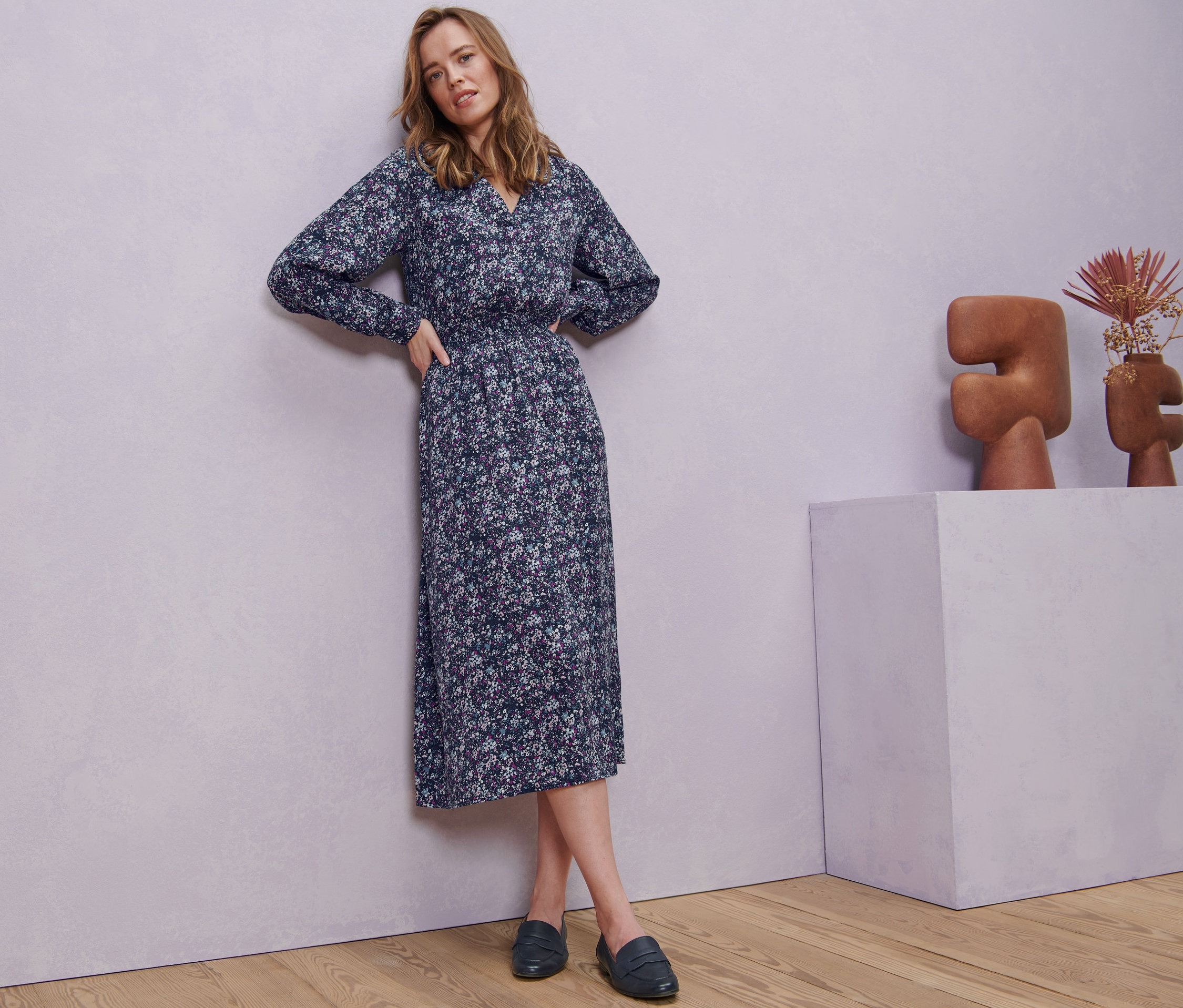 Frau posiert in geblümtem Midikleid.